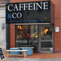 The store front of Caffeine & Co, on Manchester's St James's Square, where the most is made of what little frontage there is with a huge logo!