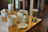 A teapot brewing at Waterloo tea with dual egg timers (one orange, one green; what tea you have determines which one you use)