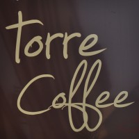 Torre Coffee, from the sign hanging outside the shop: the words "torre coffee" written in a cursive script, cream on brown.