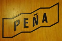 The word Peña written in black letters on wood