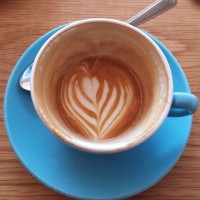 A flat white at Beany Green in Broadgate Circle, with the latte art holding its pattern all the way down to the bottom of the cup.