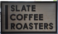 The sign from the window of Slate Coffee Roasters in Seattle: the words 'SLATE COFFEE ROASTERS', one word per line
