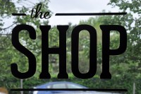 The words "The Shop" painted in black on the window.