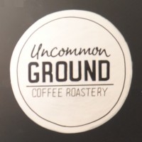 The word "Uncommon GROUND COFFEE ROASTERY" written in black inside a white circle on a black background.