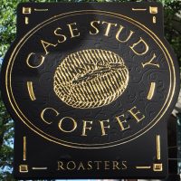 The words Case Study Coffee in gold on black written in an oval around a line-drawing of a coffee bean.