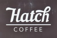 The word "Hatch", written in cursive script in white on black, over the word "COFFEE", separated by a horiztonal white line.