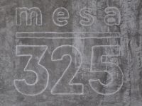 Mesa 325, written in white stencil on the grey concrete wall of Mesa 325.