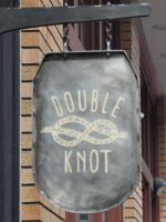 The words "Double Knot" written with the picture of a piece of rope tied into a Double Knot in the middle.