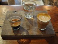 A one and one (otherwise known as a split shot), beautifully presented on a wooden tray with a glass of soda water at Cartel Coffee Lab in Tempe, Arizona.