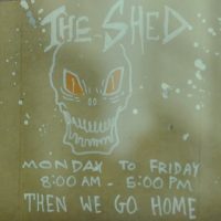 The opening times, and a grinning skull, taken from the door of Taylor St Baristas, The Shed.