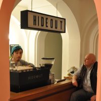 Head Barista, Jordan, talks with regular customer, David, at Hideout Coffee.