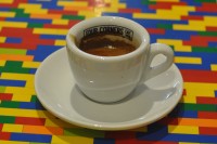 An espresso from Four Corners Cafe in a white cup with Four Corners Cafe Limited written on the inside of the rim