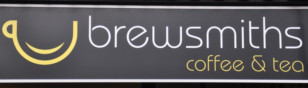 The Brewsmiths logo, a smiling yellow cup next to the words 'brewsmiths coffee & tea'