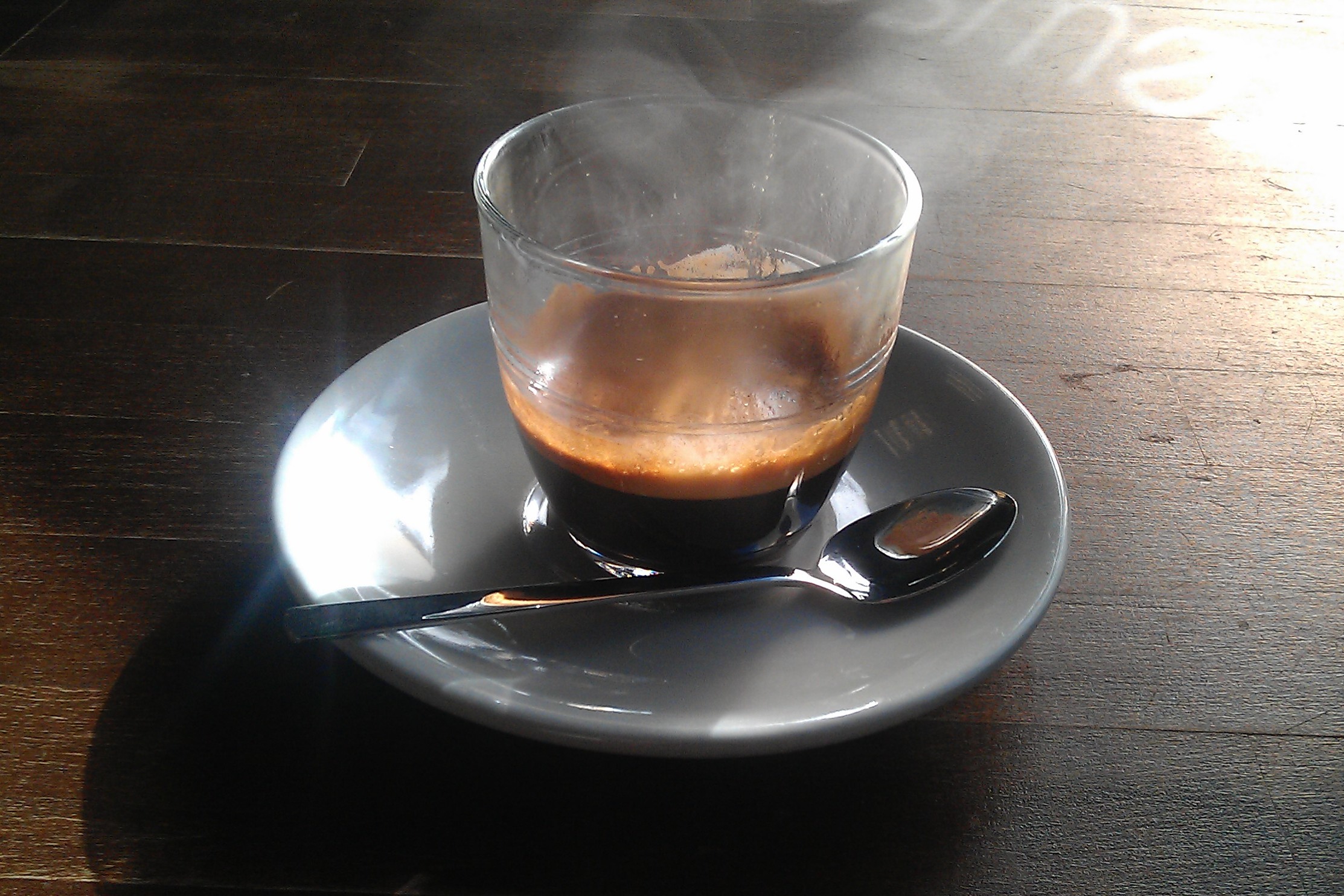 An espresso in a glass, steaming in the sunlight streaming through Brewsmith's window.