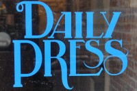 From the window of Daily Press Coffee: the words "Daily Press" written in blue in serif capitals.