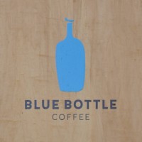 The Blue Bottle Coffee logo from the A-board outside the Chelsea coffee shop: the outline of a bottle painted in solid blue above the words "Blue Bottle Coffee".
