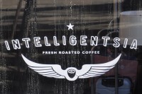 The word "Intelligentsia" written over a pair of wings, bracketing the words "Fresh Roasted Coffee", all in white.