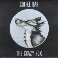 A drawing of a very smug-looking fox in a circle on a black background, with the words "Coffee Bar" above and "The Crazy Fox" below.