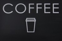 The word "COFFEE" i white on black, over a stylised outline of a takeaway coffee cup, again in white on black.