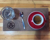 An espresso, plus a glass of sparkling water, beautifully presented at 5th Element Coffee in Madison.