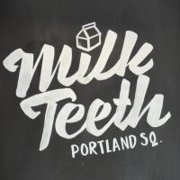 The Milk Teeth logo from the chalkboard just inside the door at Portland Square.