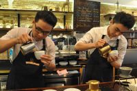 Synchronicity: two baristas pouring milk in cappuccinos at Shin Coffee, Ho Chi Minh City, VIetnam.