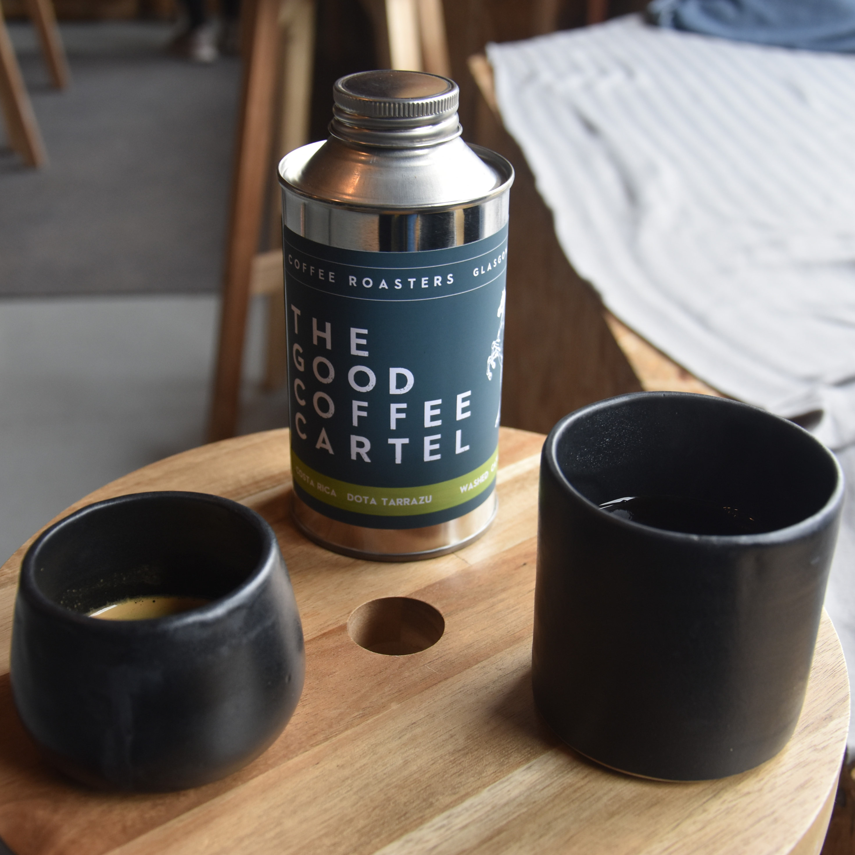 My espresso and batch-brew, both served in ceramic cups, handmade on-site at The Good Coffee Cartel, with a tin of the Costa Rican single-origin beans behind .
