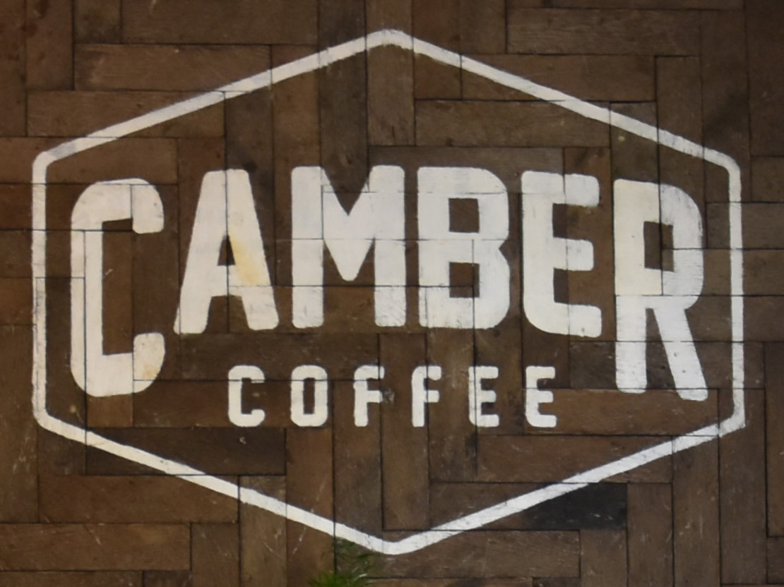 The Camber Coffee logo from the wall behind the counter.