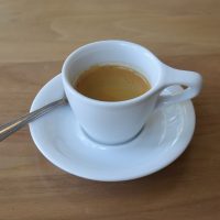 An organic Guatemalan Concepcion single-origin espresso from Kickapoo in Milwaukee, served in a classic white espresso cup with an oversized handle.