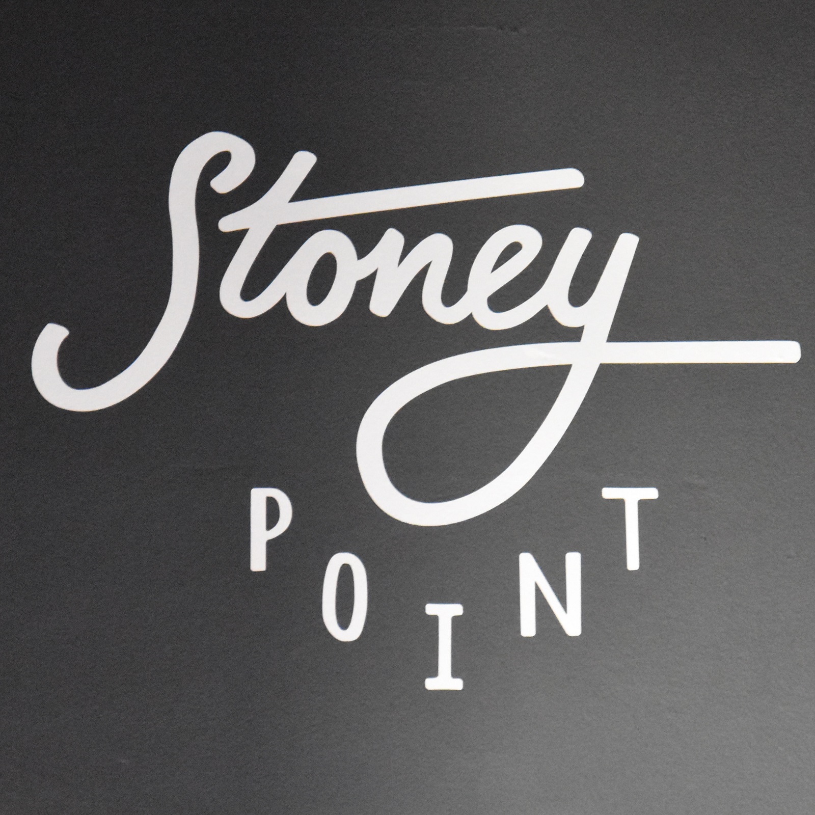 The logo / name of Stoney Point, written on the black board behind the counter.