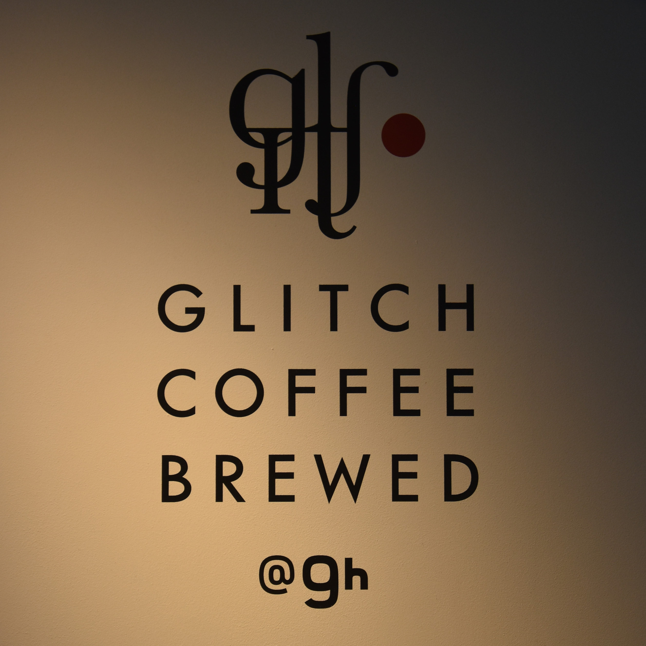 Glitch Coffee Brewed, from the wall behind the counter, with the Glitch Coffee logo above and the Nine Hours hotel logo below.