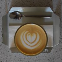 A lovely flat white from Pauseteria, served in a glass on a small, metal tray, and made with an Ethiopian single-origin roasted by Candy Cane.