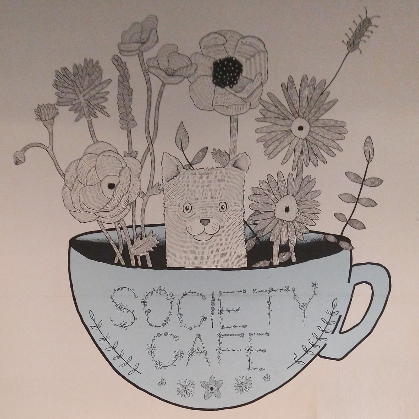 The mural on the wall of the basement in Society Cafe, The Corridor, in Bath, showing flowers growing in a coffee cup, with a small animal peaking its head out.