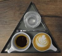 A lovely one-and-one (espresso and macchiato) plus a glass of sparkling water, beautifully presented on a triangular tray at Mythical Coffee in Gilbert, Arizona.
