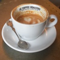 My flat white, made with the guest coffee, a washed El Salvador, and served at The Smithy, one of two Ue Coffee Roasters shops in Witney. I've drunk half of my flat white, which reveals Ue Coffee Roasters written on the inside rim of the cup.