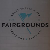 Fairgrounds, Craft Coffee & Tea | Taste One, Taste All, written on the back wall at the Bucktown location in Chicago.