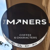 The sign from outside The Miners Coffee & Characters in Prague.