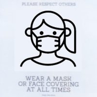Details from a sign on the door at Quarter Horse Coffee in Birmingham, requesting that you wear a mask or face covering at all times.