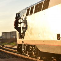 The driver climbing up in the evening sun to get into the cab of the lead locomotive of the Sunset Limit at Houston, Texas