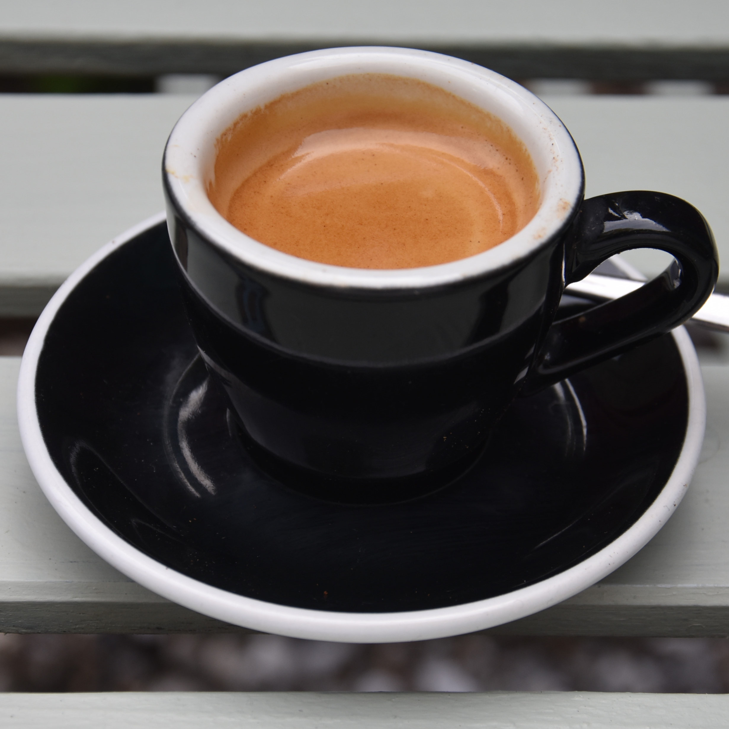 A classic espresso in a classic black cup, served at The Coffee Traveller in Chiswick.