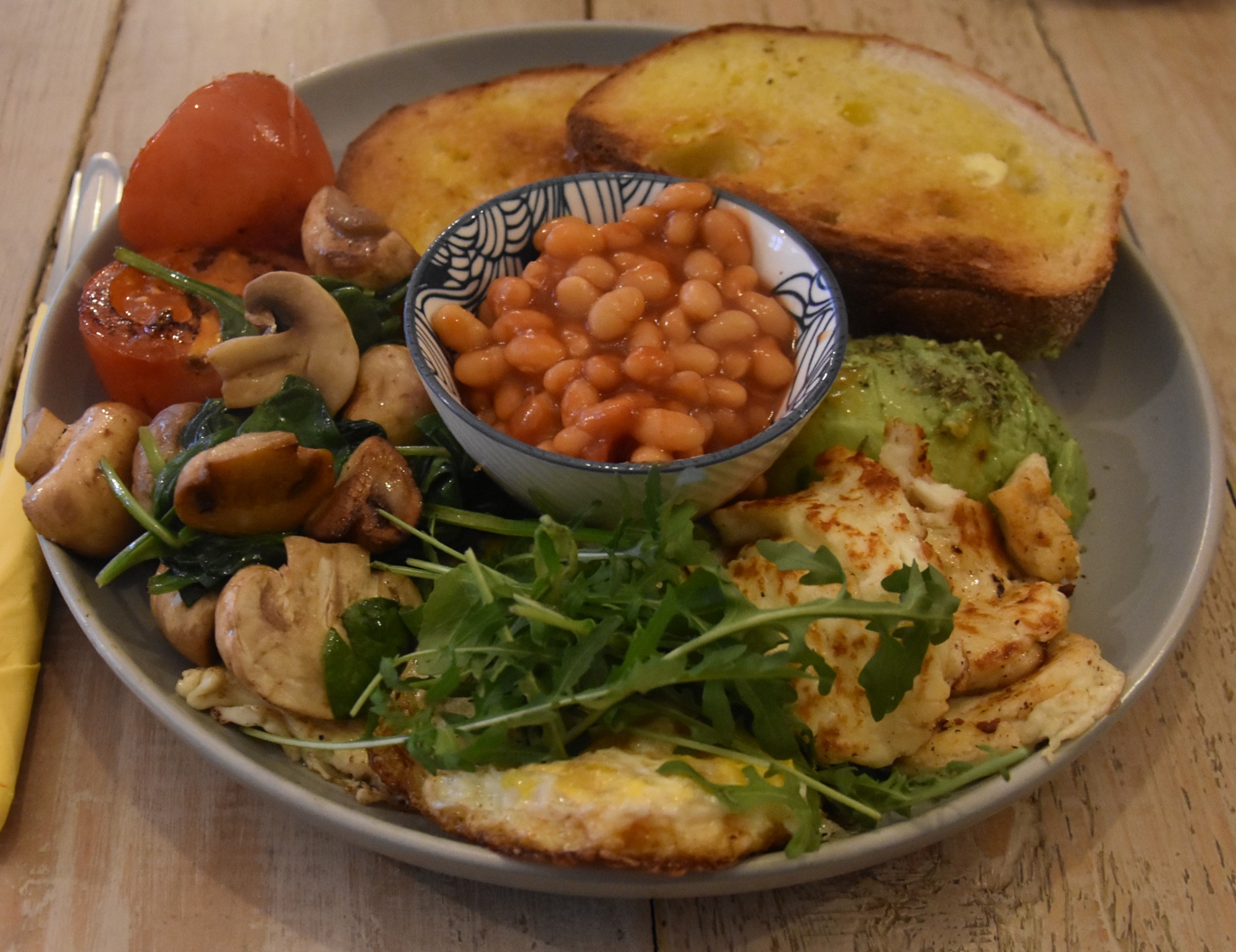 My awesome veggie breakfast which I had at Little Yellow Pig in Nantwich. Arranged around a pot of baked beans in the centre are avocado, halloumu, a pair of fried eggs, spinach, mushrooms, tomatoes and two slices of toast!
