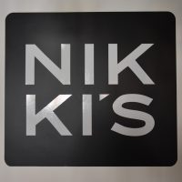 The sign from the back of Nikki's in Weybridge, with white letters on a black background.