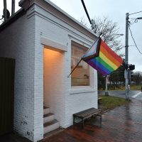 The front of Little Woodfords on Congress Street in Portland, Maine, proudly flying its Progress Pride flag.