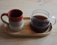 An AeroPress of an Ethiopian single-origin from Heartland Coffee Roasters, served in a carafe with a cup on the side, all presented on a wooden tray.