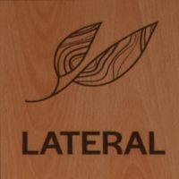 The Lateral logo, a line drawing of two leaves, with the word "LATERAL" below, burnt into wood.