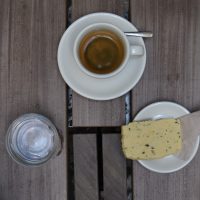 My espresso, the Sasaba, a naturally-processed single-origin from Ethiopia, seen from above, along with a glass of water and a piece of shortbread, all enjoyed while sitting out in the courtyard at Bonanza Gendarmenmarkt in Berlin.