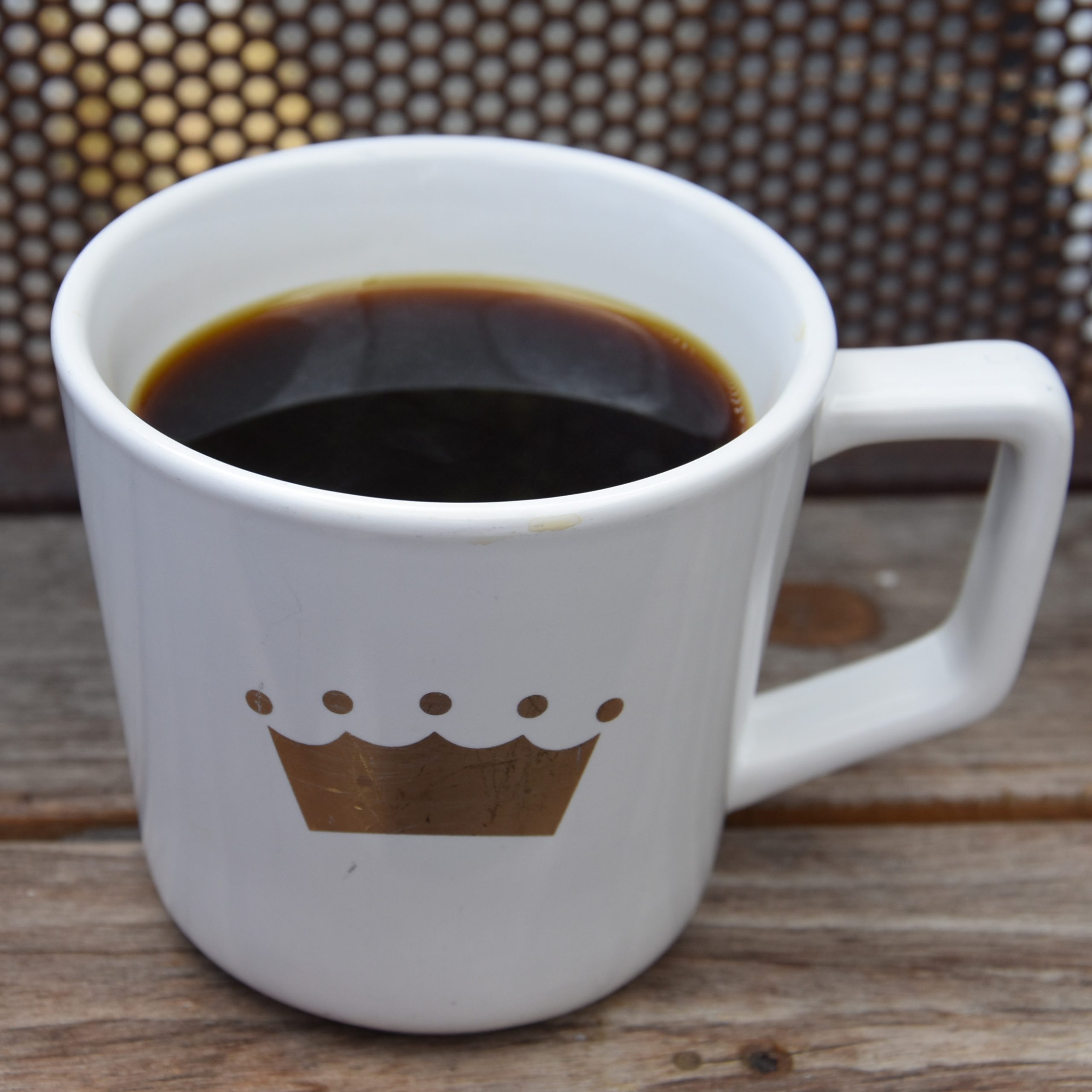 A cup of the light-roast batch brew option, the Kenya Mumwe Mahiga Double Fermented Double Washed, served in a white mug with the Crown Coffee logo on the side.