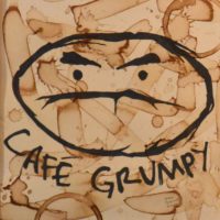 The famous Café Grumpy logo on a background of wood with multiple coffee stains, taken from above the counter in the first Café Grumpy in Greenpoint, Brooklyn.