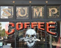 The amazing window at the front of Sump Coffee in Saint Louis with the words "SUMP COFFEE" over a drawing of a bearded white skull.