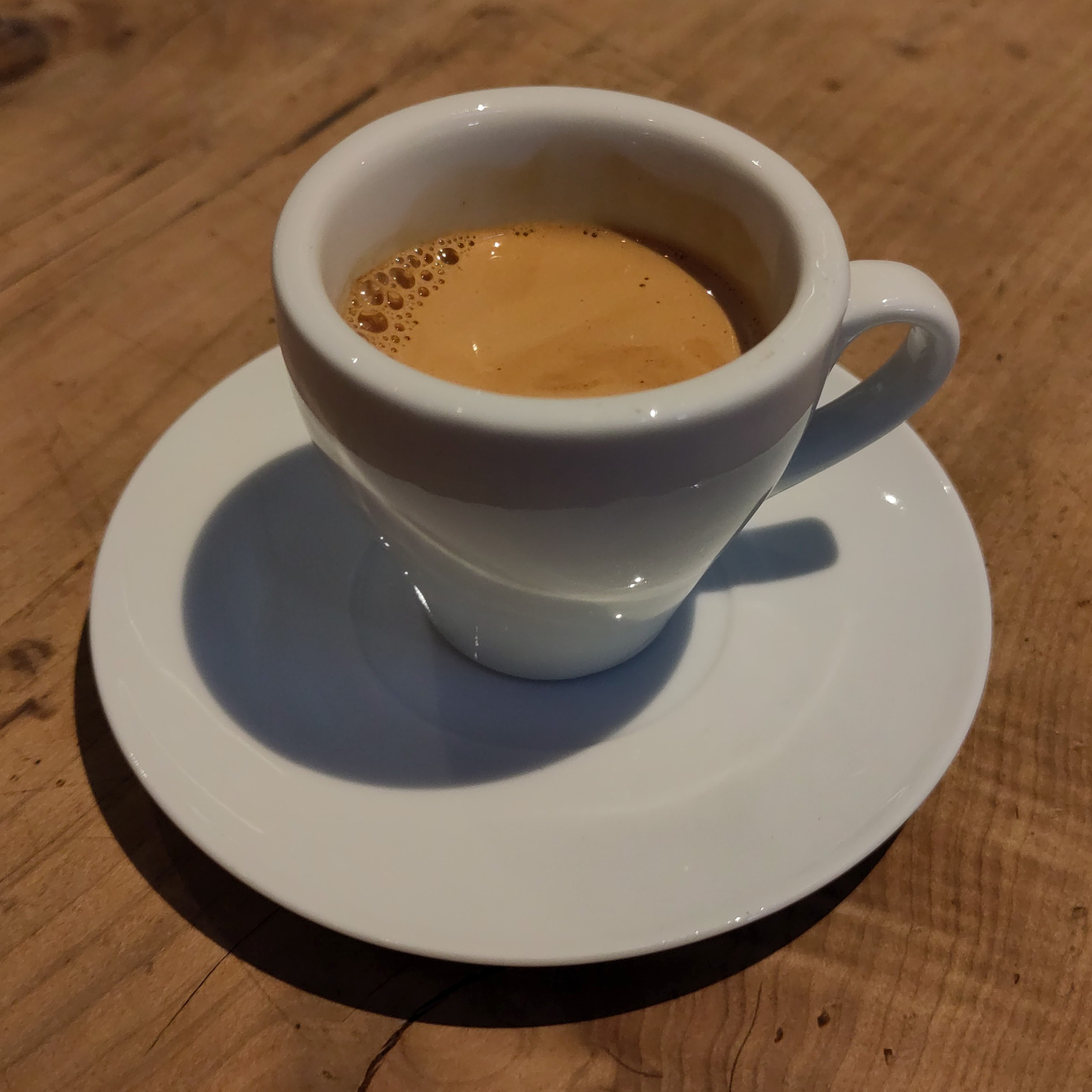 An espresso, served in a classic white cup.